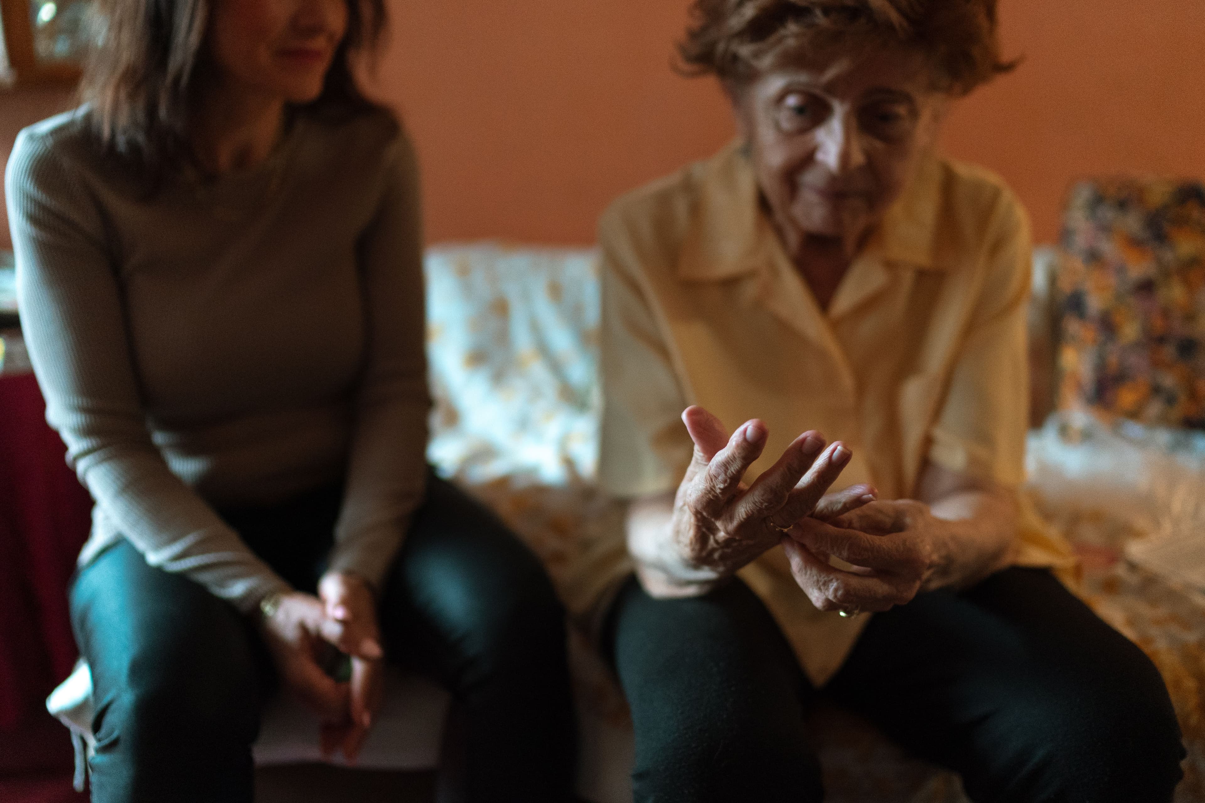 A caregiver and older adult sharing a supportive conversation at home